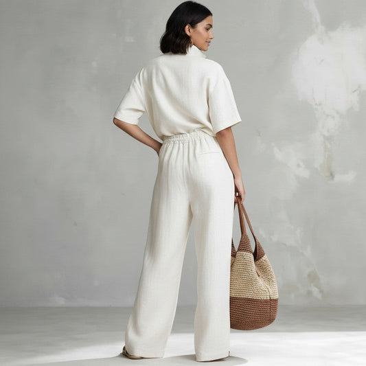 Mujer de espaldas vistiendo conjunto vestismuse blanco de dos piezas con camisa de manga corta y pantalón ancho