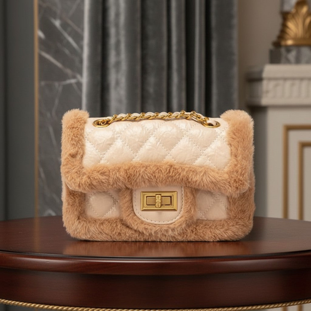 Bolso rígido vestismuse color crema con textura acolchada, detalles de pelo sintético y cadena dorada elegante.