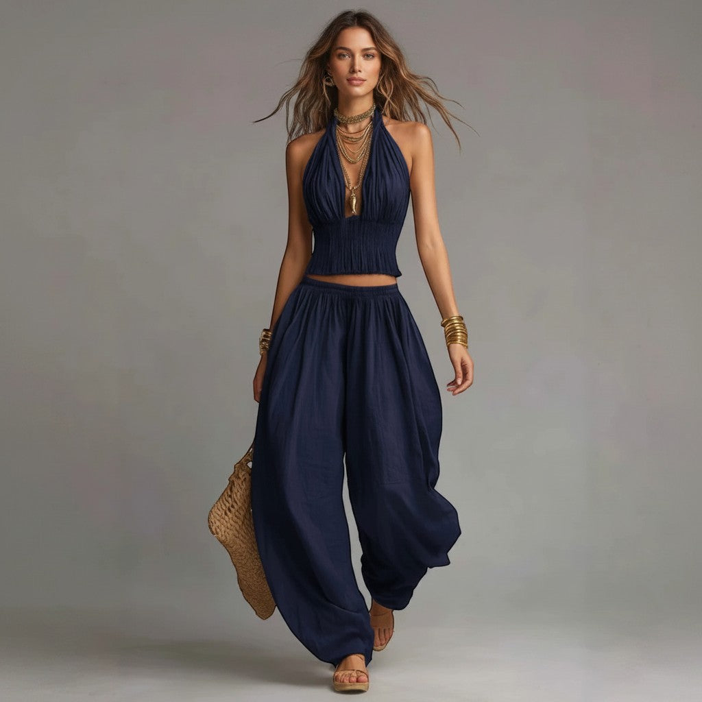 Modelo vestismuse con conjunto azul marino de top halter fruncido y pantalón ancho fluido, estilo mediterráneo.
