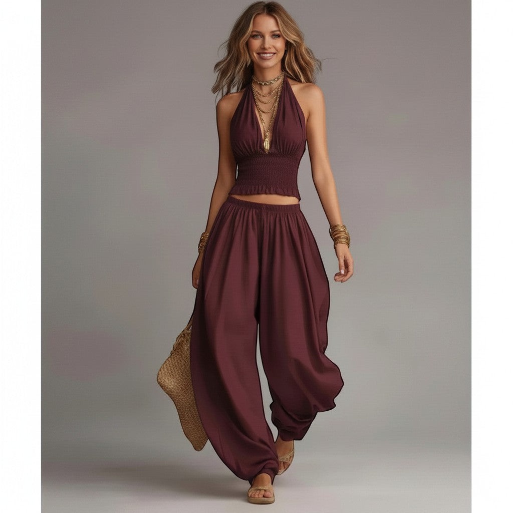 Modelo sonriente vistiendo el conjunto vestismuse color rojo vino con top halter fruncido y pantalón de pernera ancha