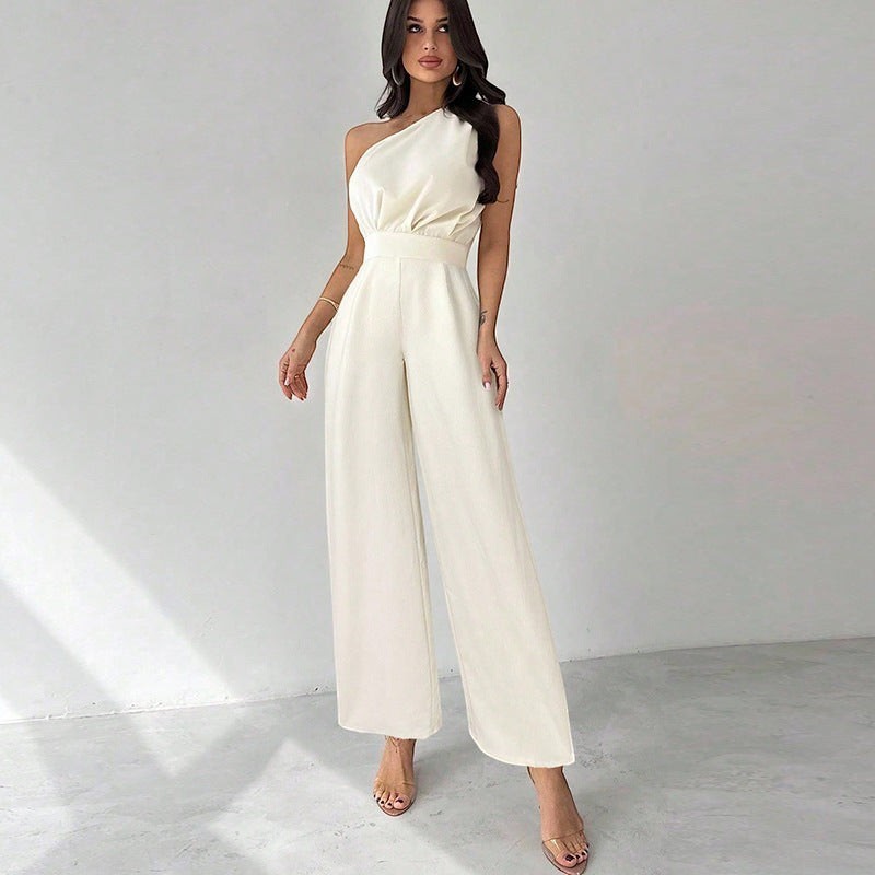 Modelo vistiendo mono largo blanco de un solo hombro con pernera ancha y diseño minimalista de la marca vestismuse